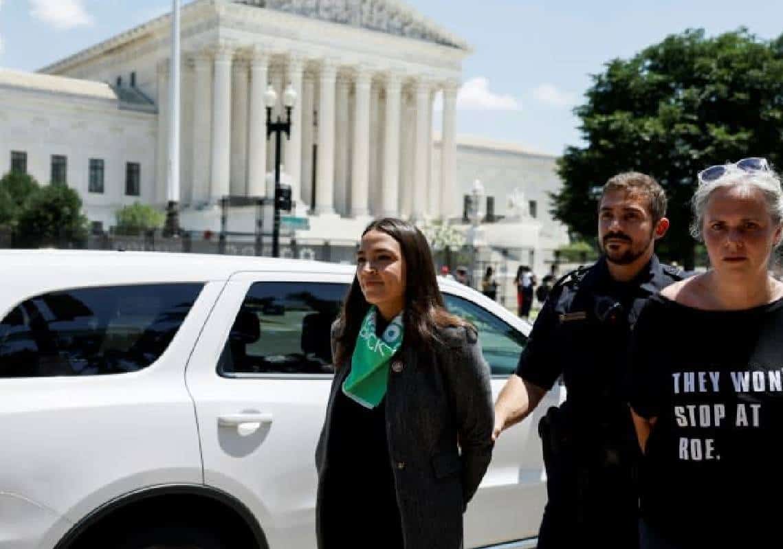 צפו: AOC מעמידה פנים שיש עליה אזיקים לאחר שנעצרה במחאה בעד הפלות מול בית המשפט העליון